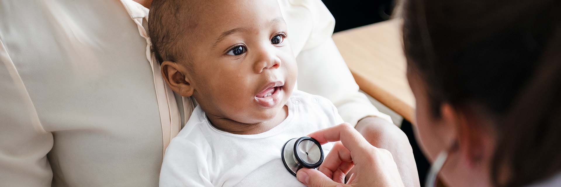 Provider using stethoscope on baby