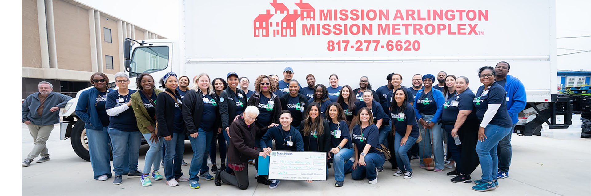 Texas Health employees work at Mission Arlington and present a check to them