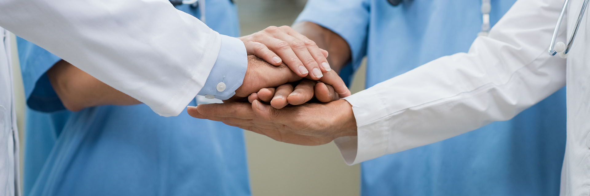Provider hands stacked on top of each other