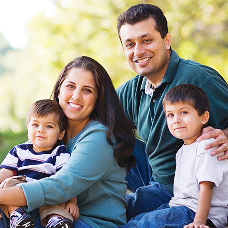 Young Family Sitting Outdoors